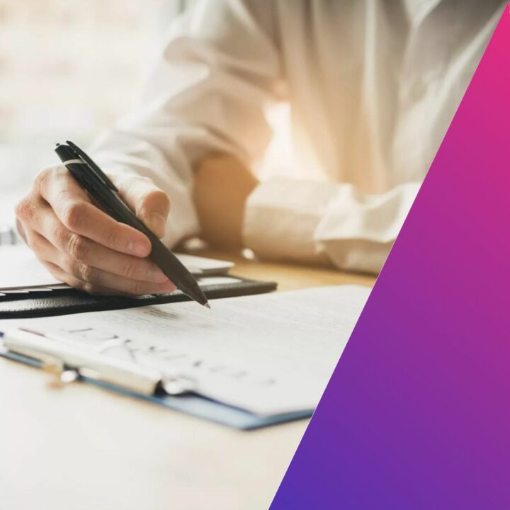 Male professional holding a pen and reading over paperwork