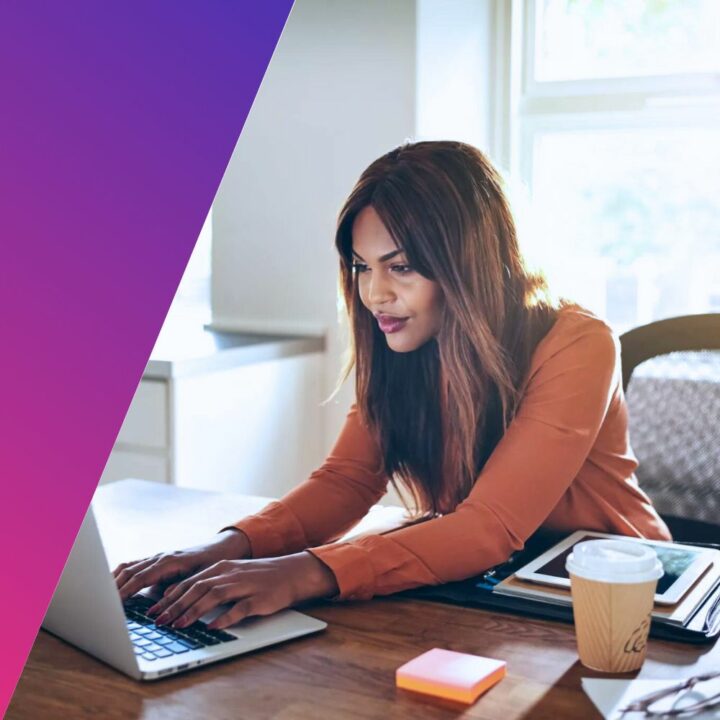 Young female professional working online with a laptop while sitting at a desk in her home office