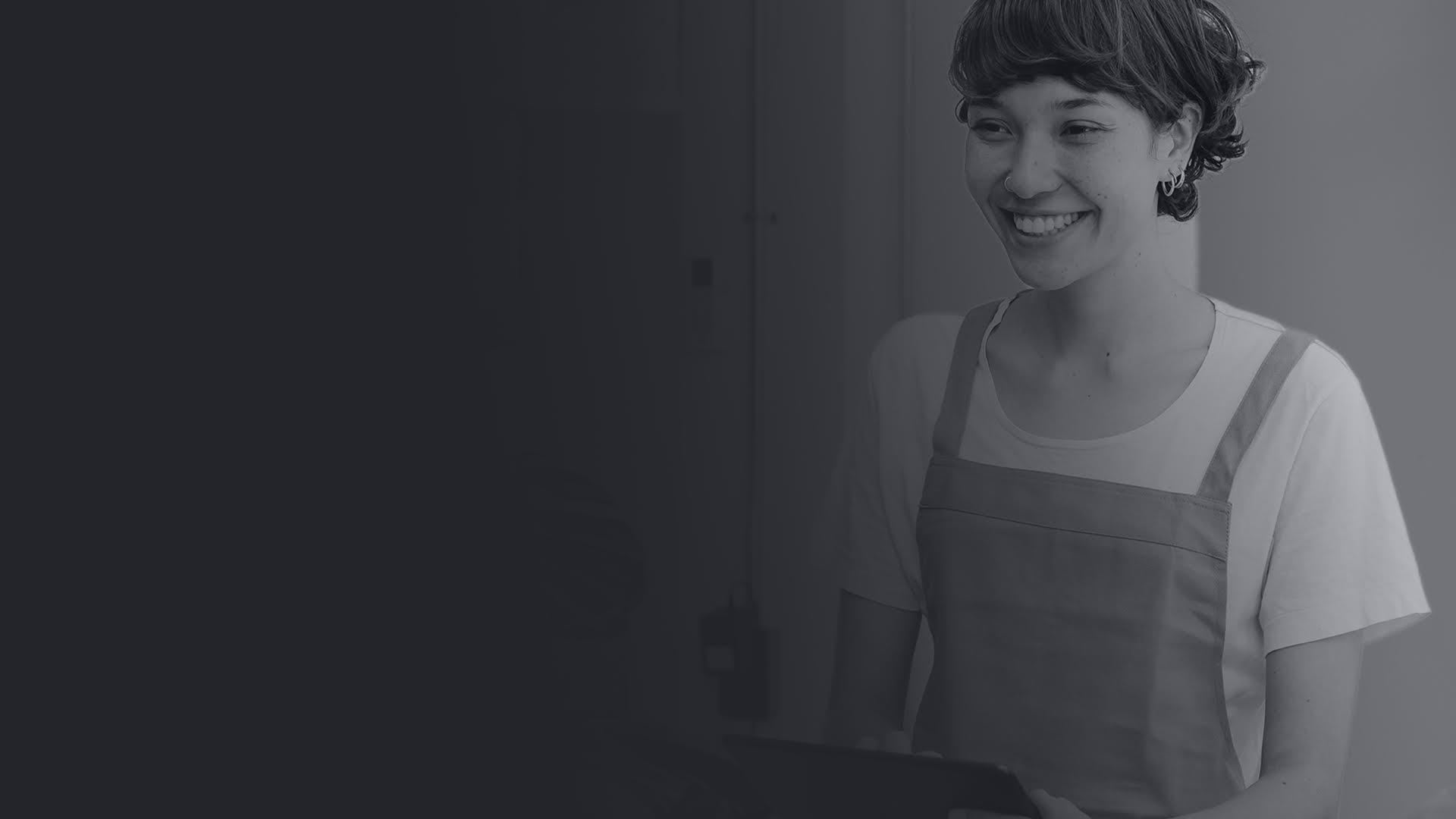 Female professional smiling wearing an apron and holding a clipboard