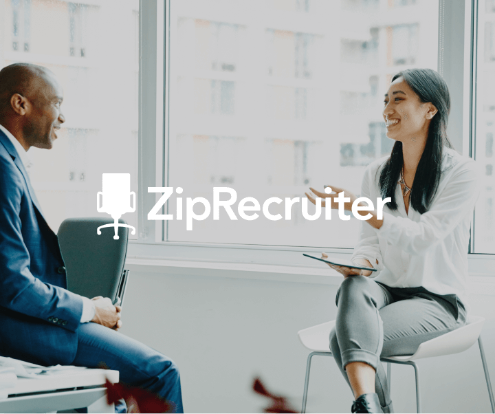 Male professional in a suit sitting in a chair interviewing a female candidate with the ziprecruiter logo