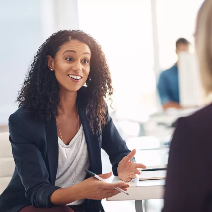 Interview with a happy, excited and confident employer talking to a shortlist candidate for a job. Candidate is asking unique interview questions.