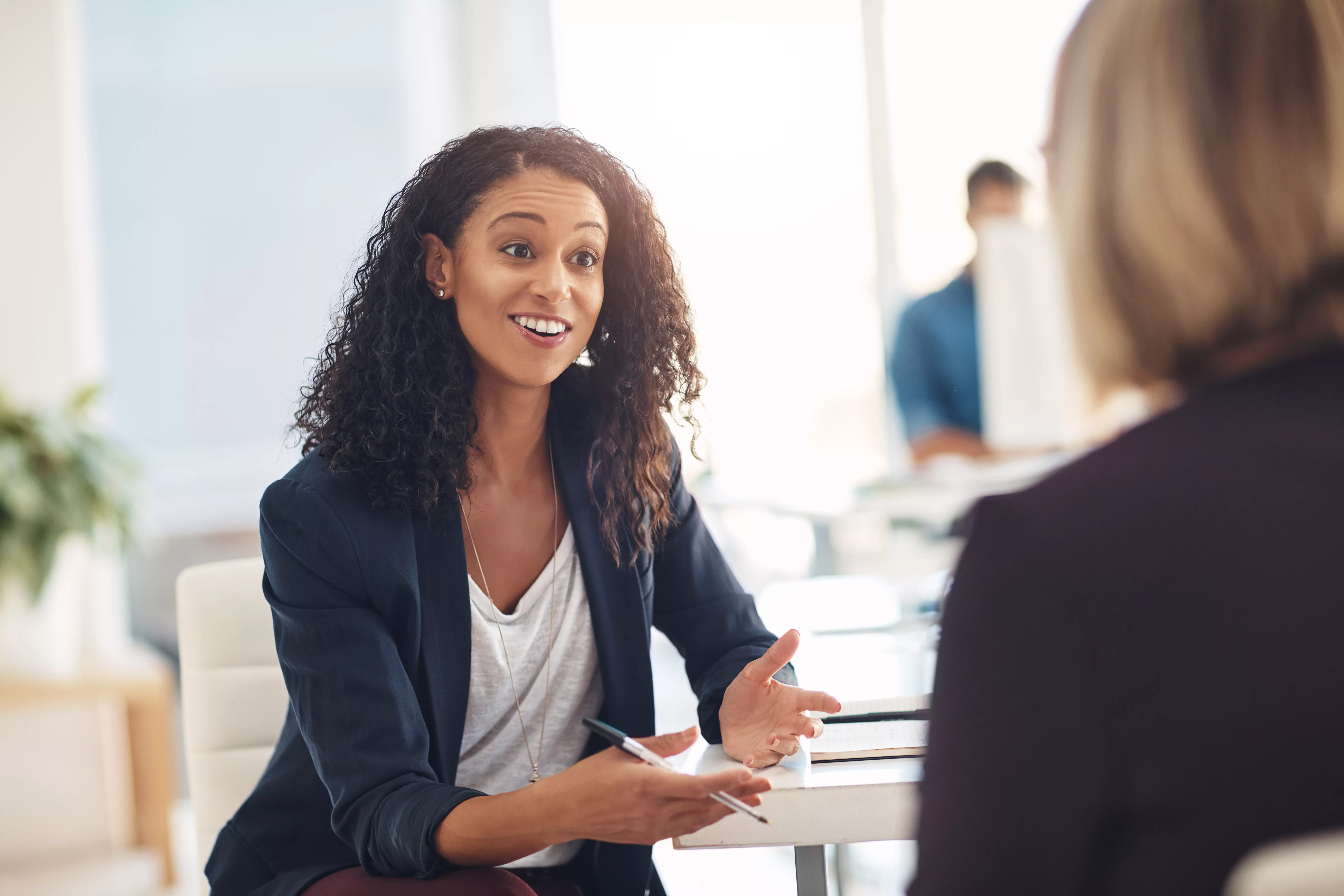 Interview with a happy, excited and confident employer talking to a shortlist candidate for a job. Candidate is asking unique interview questions.