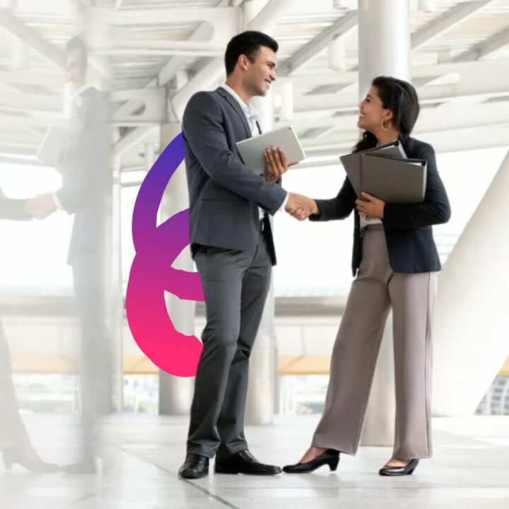 Female business woman standing holding a binder introducing herself to business man. Both in professional attire shaking hands in the office.