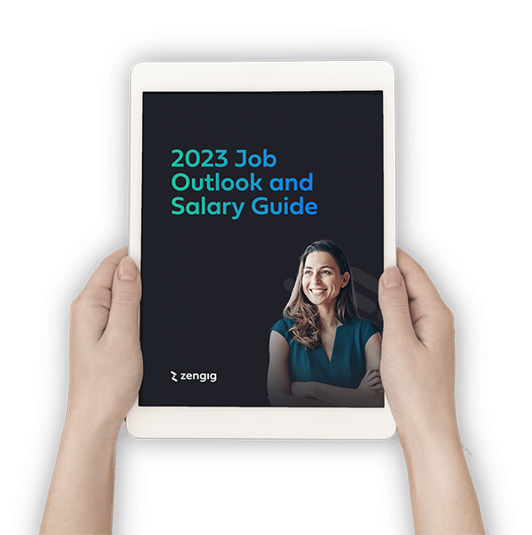 Two hands holding a white iPad with 2023 Job Outlook and Salary Guide on the screen
