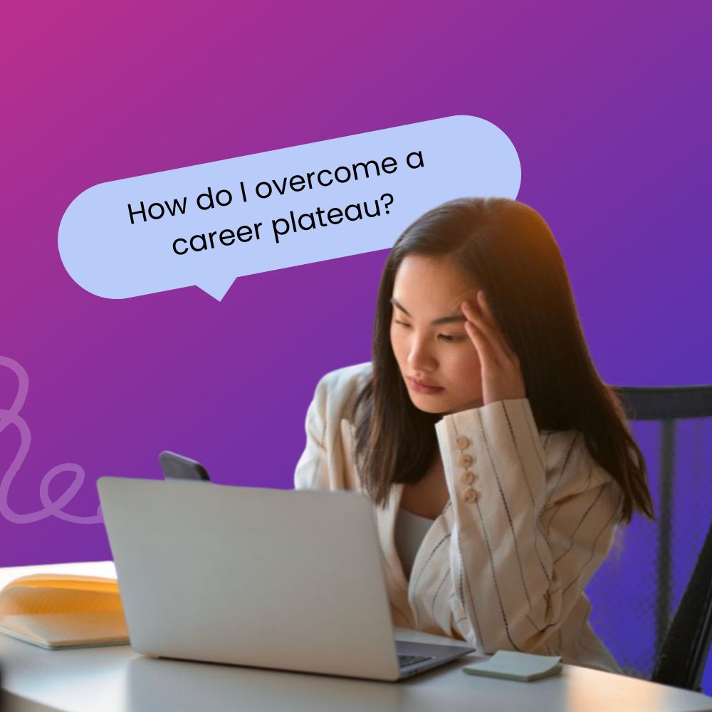Woman professional looking unhappy sitting at her desk in an office resting her head on her hand looking at her phone behind a laptop with a speech bubble above her head that reads, "How do I overcome a career plateau?"