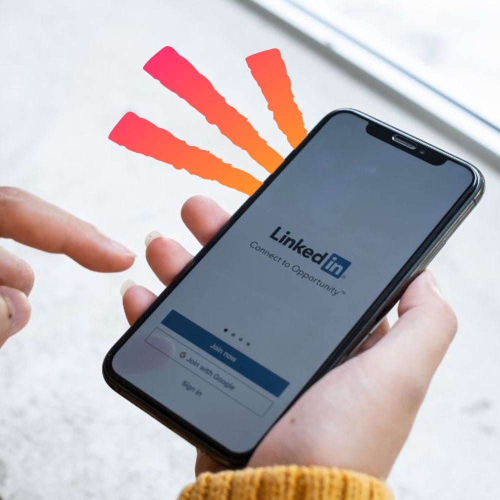 Professional holding an iPhone with the LinkedIn login open