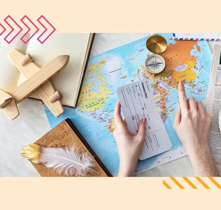 College graduate pointing at china on a world map showing where they are going to work abroad. Wooden plane on a notebook and a compass on the world map.