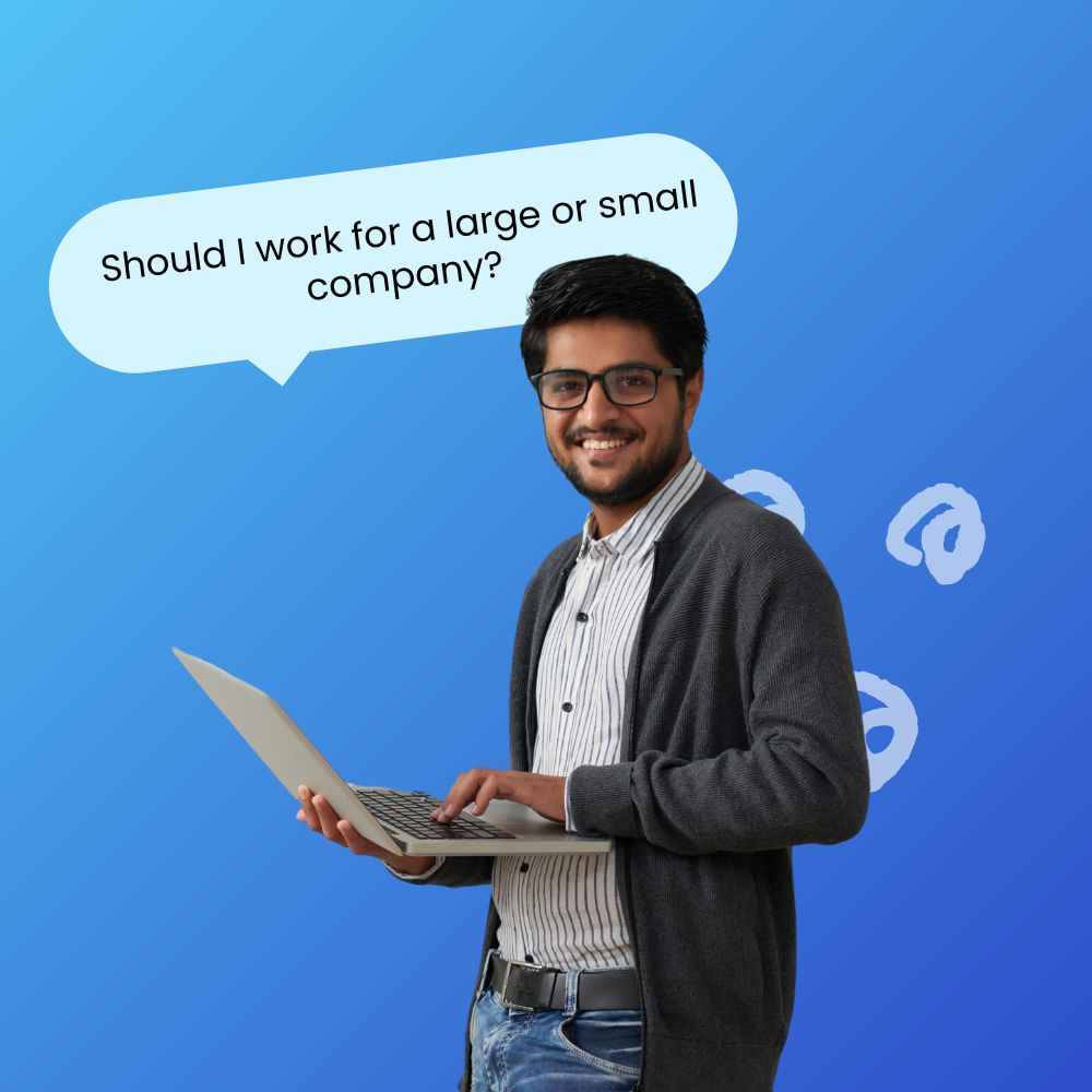 Young professional male smiling wearing a sweater holding and typing on his laptop and a speech bubble above his head that reads, "Should I work for a large or small company?"